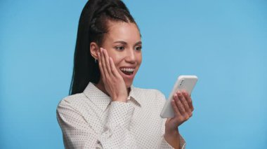 Genç profesyonel bir kadın akıllı telefon mesajı okurken heyecanlanmış görünüyor. Terfi almasına şaşırmış ve sevinmiş..