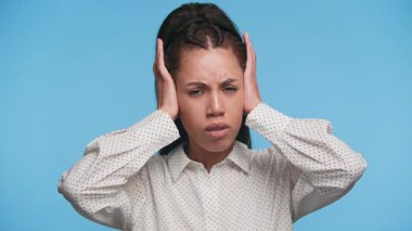 Hayal kırıklığı ya da stres içinde el ele tutuşan genç bir kadın, zihinsel yükü ifade ediyor ya da gürültüyü engellemeye çalışıyor.