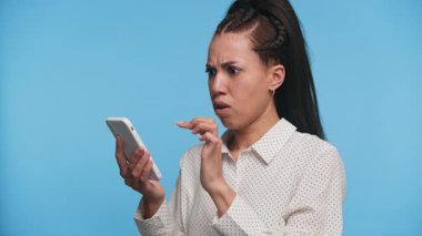 Sinirli kadın telefonu tutuyor ve kafaya dokunuyor. Kafa karışıklığı ya da endişeyi dile getiriyor. Muhtemelen kötü haber ya da teknik sorunlar yüzünden..