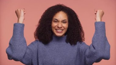 Neşeli genç kadın zaferi ve heyecanı büyük bir gülümsemeyle ifade eder. Kişisel zaferi ya da başarıyı kutlar..