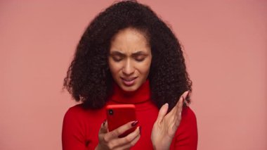 Kırmızı balıkçı yakalı mutsuz kadın hayal kırıklığıyla akıllı telefona bakıyor. Hayal kırıklığı yaratan online alışveriş deneyimine tepki veriyor..