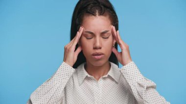 Gözleri kapalı parmaklarını bastıran genç bir kadın. Rahatsızlık ya da hastalık belirtileri gösteriyor. Muhtemelen stresten ya da migrenden..