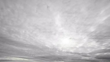 Hızlı hareket eden katmanlı gri bulutları gösteren dinamik bir gökyüzü görüntüsü karamsar ve atmosferik bir görsel efekt yaratır..