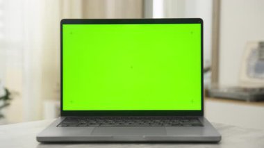 Yeşil ekranlı, video düzenleme ve birleştirme amaçları için ideal bir dizüstü bilgisayarı gösteren dramatik yakınlaştırma veya zolly efekti.