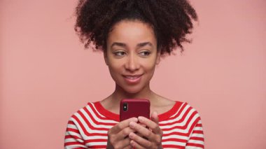 Telefonunu tutan, dudaklarına dokunan, düşünceli genç bir kadın. Bir mesaj yazarken ya da akıllı telefondan cevap verirken düşünceli..