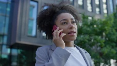 Şehir sokaklarında gezerken, spor ceket giyip işe yürürken akıllı telefondan konuşan genç profesyonel bir kadın..