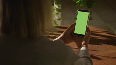 Elinde boş yeşil ekran olan akıllı telefonu olan bir kadının yakın plan fotoğrafı. Uygulama modelleri ya da UI sunumları için mükemmel..