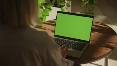 Yeşil ekranda dizüstü bilgisayar kullanan bir kadının arka plan görüntüsü, modeller veya UI gösterileri için idealdir..