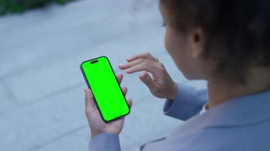 Profesyonel kadın akıllı telefondan yeşil ekran maketi ile kayıyor. Uygulama tasarımı veya dijital içerik tutucuları için mükemmel..