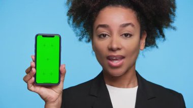 Yeşil ekranlı akıllı telefonu elinde tutan bir kadının yakın plan fotoğrafı, uygulama tasarımı, sunumu veya müşteri geri bildirim kavramları için kullanışlı.