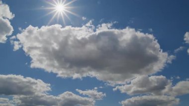 Dinamik zaman atlaması sahnesi, parlak mavi gökyüzünde süzülen tüylü bulutları ve yukarıda parlayan güneşi gösteriyor, barışçıl ve doğal bir atmosfer yaratıyor..