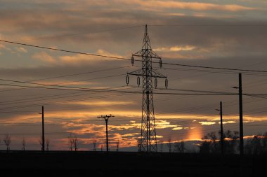 High voltage pole. Electrical distribution network. Infrastructure. High voltage pylons. Sunset. clipart