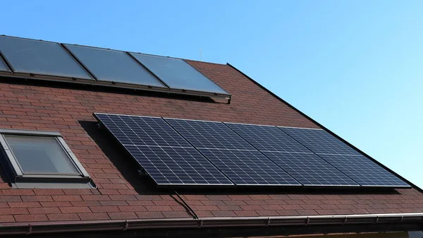 Termosolar ve fotovoltaik panellerle evin çatısını. Kendi kendine yeten bir ev. Yeşil enerji. Yeşil anlaşma.