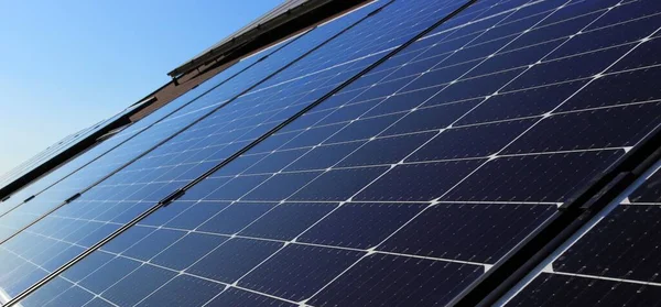 Fotovoltaik elektrik santrali evin çatısında. Sağdan bak. Evin çatısı fotovoltaik panellerle kaplı. Yeşil enerji.