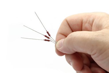 El üç parça rezistans tutuyor. Standart elektronik parçalar. Beyaz arkaplan.