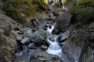 Bir şelalenin hareketli fotoğrafı. Kaya oluşumları arasında akan su. Alp bölgesinde Kitzlochklamm Taksi Geçidi.