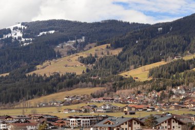 Avusturya, Tirol 'deki Kirchberg: Avusturya' daki Alp kasabası. Vadide bahar başlıyor, dağ zirveleri karla kaplı..