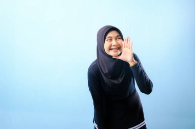 Siyah tesettürlü bir kadın elleriyle jest yapıyor. Bağırarak ya da bir şeyler söyleyerek bir jest yapıyor.