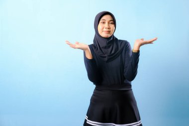 Siyah tesettürlü bir kadın elleri cebinde kameraya bakıyor. Dalgın bir ruh hali içinde.