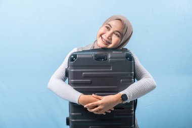 Bir kadın siyah bir bavul tutuyor ve gülümsüyor. Macera ve heyecan kavramı. Kadın bir yolculuğa hazırlanıyor..