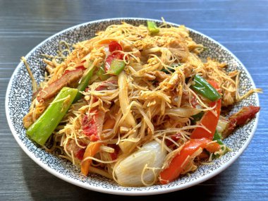 Lezzetli bir tabak Çin usulü kurutulmuş erişte, yanında char siu domuz eti, karides, tavuk ve sebze ve baharatlı biber.