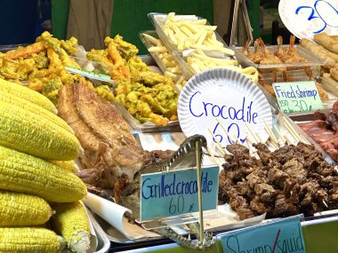 Khao Lak, Tayland 'da bir markette pişirilmiş timsah eti ve diğer lezzetli şeyler satılıyor.