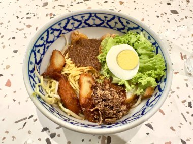 Lezzetli bir kase Çin eriştesi ve dilimlenmiş tavuk, haşlanmış yumurta ve baharatlı acı biber soslu fasulye filizi.