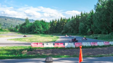 Güneşli bir günde Yeşil Orman ve Yuvarlanan Tepeler arasında heyecan verici Go-Kart Yarış Pisti