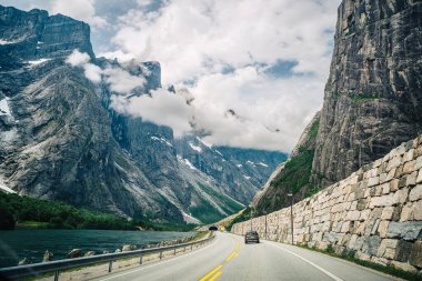 Dramatik uçurumları ve bereketli vadisi olan Manzaralı Dağ Yolu Bulutlu Tepelere çıkan Huzurlu Manzara