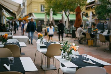 Güneşli bir günde Canlı Şehir Sokak Atmosferinde Zarif Çiçek Dekoru ile Büyüleyici Açık Cafe Dekorasyonu