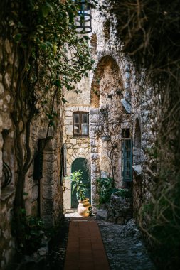 Yemyeşil Yeşiller ve Kemerli Kapıları olan Avrupa 'nın Tarihi Bir Köyünde Büyüleyici Dar Taş Geçidi