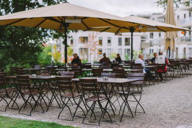 Şehir Merkezinde Konforlu Şemsiyeler ve Boş Masalarla Büyüleyici Açık Cafe Terası