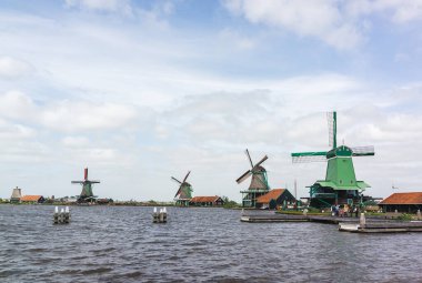 Uçsuz bucaksız Gökyüzü Altında Huzurlu Sulara Bakan Hollandalı Yel Değirmenleri Geleneksel Kırsal Mimariye Güzel Bir Bakış