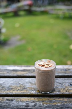 Yıpranmış Tahtada Badem Topları olan Rustik Meyve Smoothie kavanozu