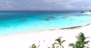 Okyanus manzarası, yeşil palmiye ağaçları, kumlu plajlar, oteller, yüzen insanlar, güneşli yaz gününde mavi sularda yüzen tekneler ve yatlar. Dron 'un deniz manzarası, beyaz kum. Tropikal. Zanzibar, Afrika