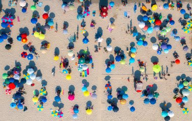 Kumlu sahildeki renkli şemsiyelerin havadan görünüşü, yazın günbatımında insanlar İtalya, Sardunya 'da. Tropik bir manzara. Seyahat ve tatil. İHA 'nın yukarıdan aşağıya bakışı. Tropikal desen. Kavram