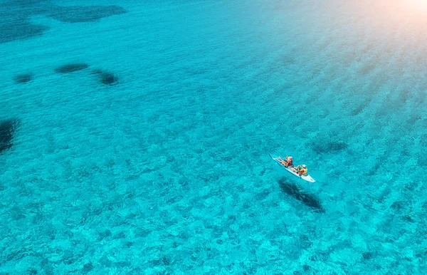 夏の晴れた日には青い海の人々とカヤックの空中ビュー 澄んだ紺碧の水の中に浮かぶカヌーの上の男と女 イタリアのサルデーニャ島 熱帯の風景 ボードだ アクティブな旅行 トップ表示 — ストック写真