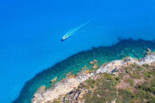空中看蓝色大海中的浮船 夏日阳光明媚 空旷的岩石海岸 透明水中的石头 海湾的顶级无人机图像 旅行背景 在意大利撒丁岛旅行 — 图库照片