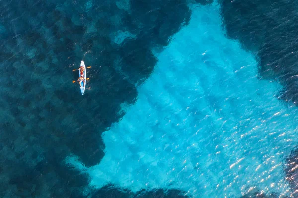 夏の晴れた日には青い海の人々とカヤックの空中ビュー 澄んだ紺碧の水の中に浮かぶカヌーの上の男と女 イタリアのサルデーニャ島 熱帯の風景 ボードだ 旅行だ 海の眺め — ストック写真