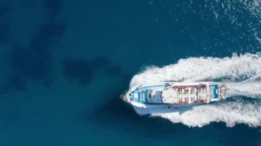 Yazın güneşli bir günde mavi denizde yüzen güzel bir yatın havadan görünüşü. Sardunya adası, İtalya. Hız teknesi, deniz kıyısı, şeffaf su. Seyahat et. Tropik bir manzara. Yat.