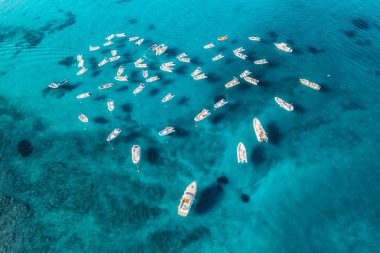 Yazın günbatımında mavi denizde kalp şeklinde motorlu teknelerin hava görüntüsü. Sardunya, İtalya 'ya seyahat. Sürat tekneleri, yatlar, okyanus, şeffaf gök mavisi su. Tropik