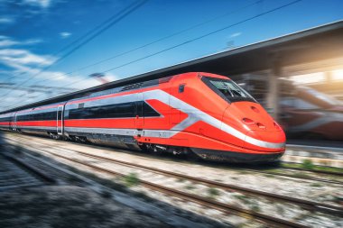 Tren istasyonunda kırmızı hızlı tren hareket ediyor. Hızlı hareket eden modern şehirlerarası tren ve bulanık arka plan. Demiryolu platformu. İtalya 'da demiryolu. Ticari ve yolcu taşımacılığı
