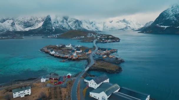 雪の岩 リボルバー 冬の日の出に紫色の曇りの空が付いている島の空中眺め ノルウェーのロフテン諸島 レイン村のトップドローンビュー ドラマティック — ストック動画