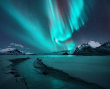 Kuzey Işıkları, karlı dağlar, kumlu plaj, yıldızlı kış gecesinde dere. Lofoten Adaları, Norveç. Muhteşem Aurora Borealis. Kutup ışıklarıyla gökyüzü. Aurora, deniz, dere, kardaki kayalar