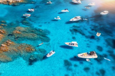 Yazın güneşli bir günde mavi denizde lüks yatların ve teknelerin hava manzarası. Sardunya, İtalya 'ya seyahat. Sürat tekneleri, yatlar, deniz bölmesi, kayalık sahil, şeffaf su. Deniz Burnu. Seyahat