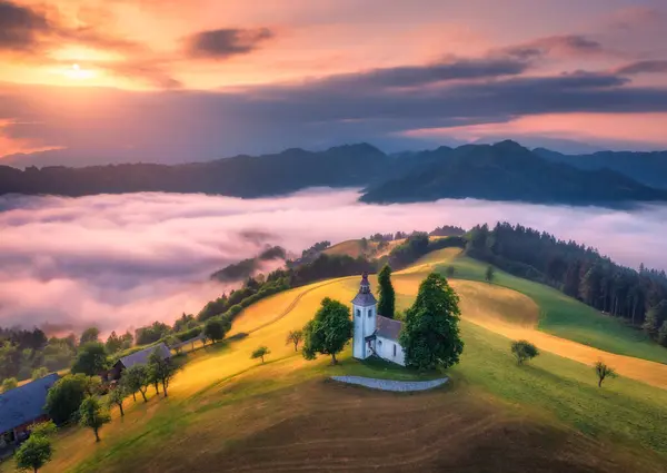 Slovenya Yaz Aylarında Sisli Bir Gündoğumunda Tepedeki Küçük Kilisenin Pembe Telifsiz Stok Fotoğraflar