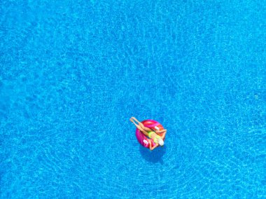 Yazın güneşli bir günde, havuz kenarında yüzen genç bir kadının hava manzarası. Güzel bir kızın en iyi drone görüntüsü, mavi su. Pwani Mchangani, Zanzibar. Seyahat geçmişi. Tropikal manzara