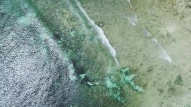 Okyanustaki gelgitte mercan resifindeki dalgaların havadan görünüşü, beyaz kum, güneşli yaz gününde Zanzibar 'da mavi deniz. Mercan resifinin üst drone görüntüsü, berrak su. Tropikal sahil. Deniz kenarında. Doğa