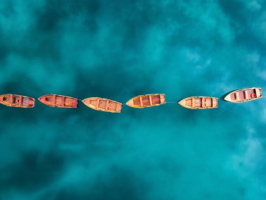 Braies Gölü, Dolomitler, İtalya 'daki güzel ahşap teknelerin hava manzarası. Teknelerin en iyi drone görüntüsü, yazın gün batımında suda gökyüzü yansıması. Renkli manzara. Seyahat et. Alp Gölü 'nün üstünden bak