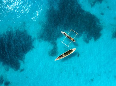 Balıkçı teknelerinin havadan görünüşü, yazın günbatımında açık masmavi suyla deniz. Şeffaf okyanusta yüzen teknelerin en üst drone görüntüsü. Zanzibar 'a git. Tropik deniz manzarası. Egzotik deniz kenarı
